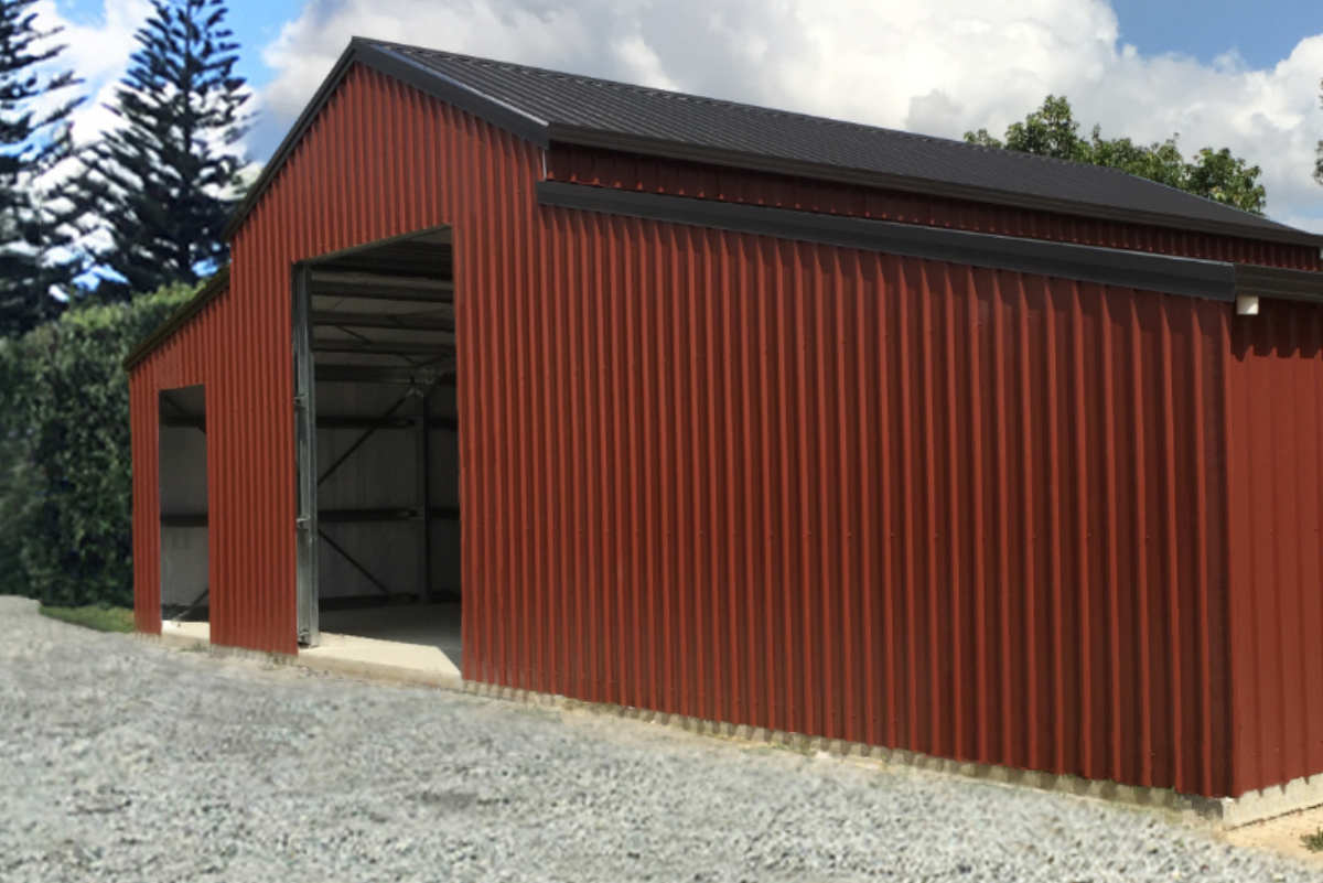 Rust-red steel barn with large open bays